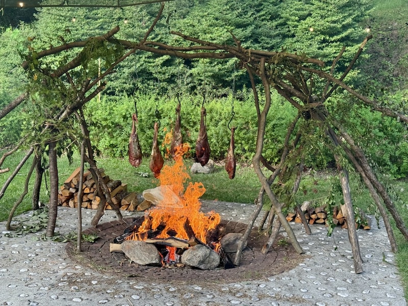 肉汁が焼け石や薪に滴り落ち、香ばしい香りが漂う