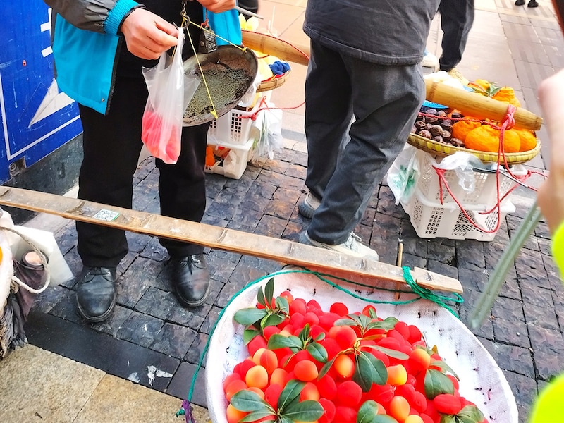 吊りはかりでグラム売りされる果物。ちなみに露店でもほとんどのものがQRコード決済だった