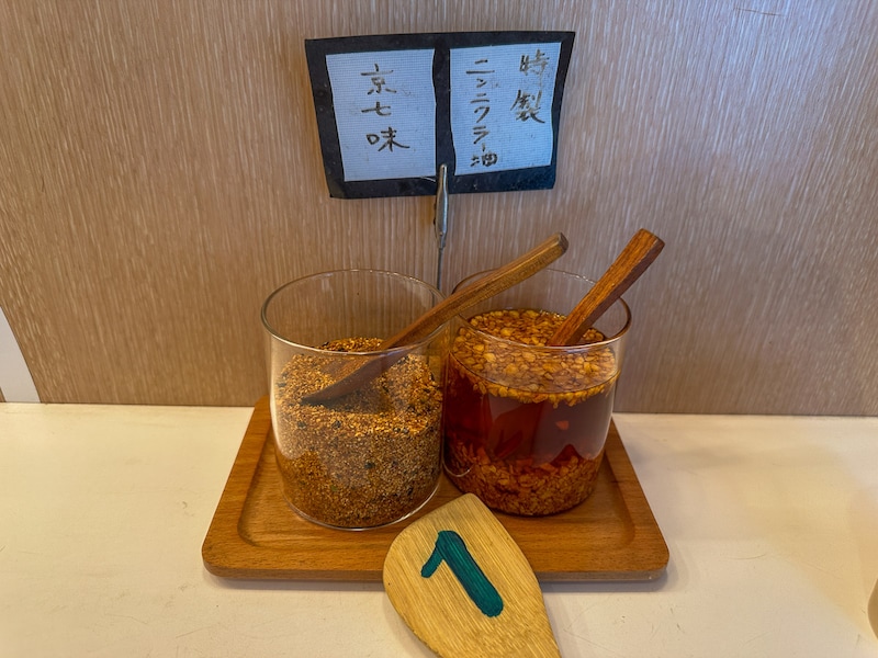 カウンターに置かれている特製ニンニクラー油と京七味