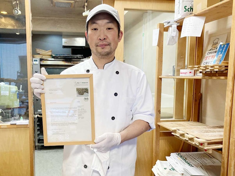 ショーマッカー本店発行のディプロマを掲げる店主の清水さん。手にするのは技術をしっかりと継承していることを認められた大事な証