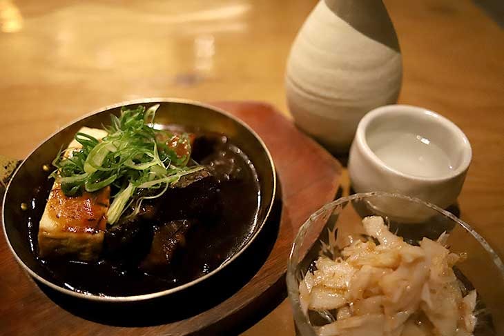 左：謹製デミ味噌牛煮込み 690円、右：梅水晶350円、熱燗1合490円