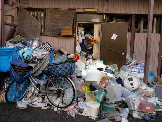 ゴミを拾って団地の廊下に並べる70代男性