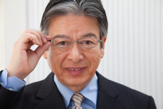 眼鏡のフレームを掴むビジネスマン