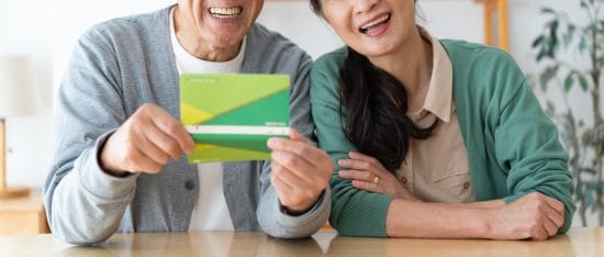 通帳をもって笑顔の日本人