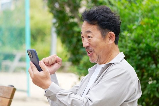 スマートフォンを使う中年の男性