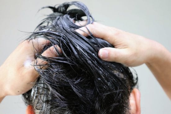 シャンプーをする人物の後ろ姿