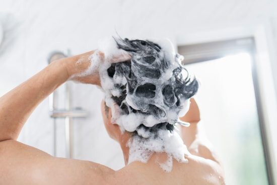 お風呂で髪を洗う40代男性