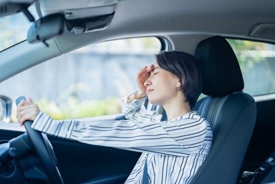 車の運転に疲れる女性