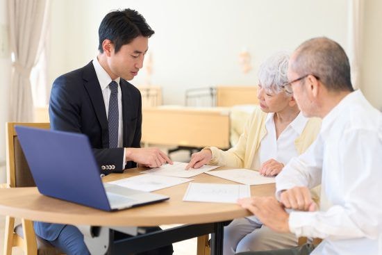 シニアに営業をするアジア人ビジネスマン