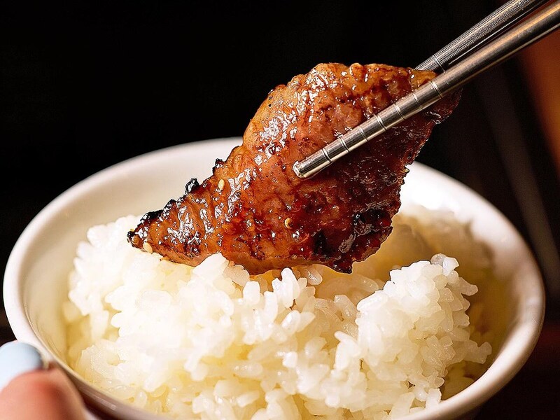 虎ノ門『虎ノ門 肉と日本酒』のタレ肉でご飯を巻いている様子