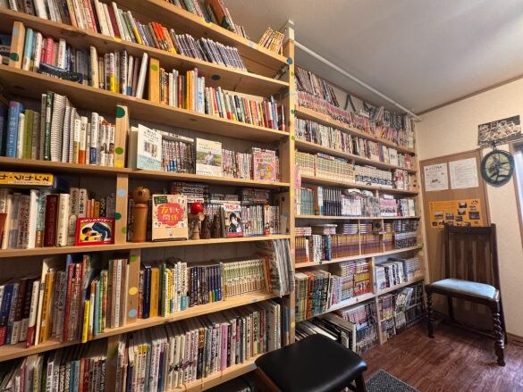  壁一面の本棚には寄贈された本がびっしりと並んでいる