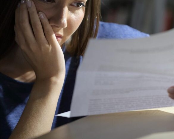 紙を読んで悩む女性