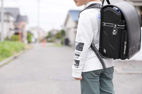 登下校中のランドセルを背負った小学生の少年