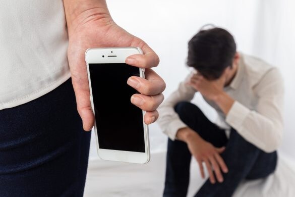 スマホを手に男性に詰め寄る女性