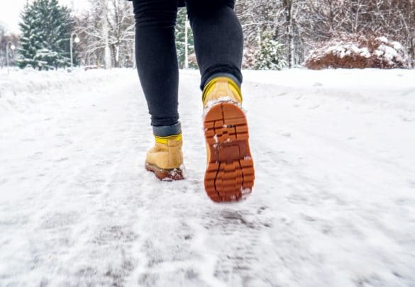 雪の中を薄着で歩く女性