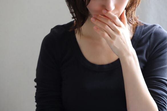 驚いて口元に手を当てる女性