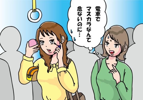帰宅ラッシュの電車でメイクをする女性