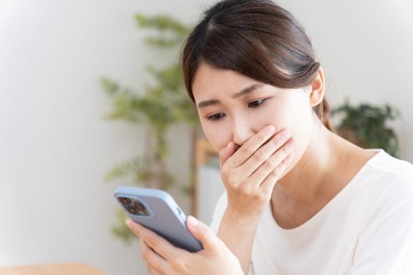 スマホを見て衝撃を受ける女性
