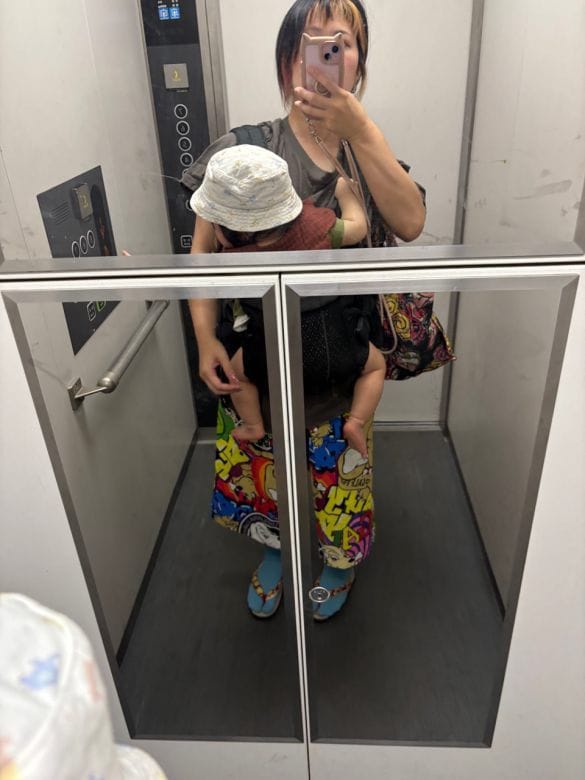  筆者と息子。よく見ると息子がエレベーターのボタンを押そうとしている
