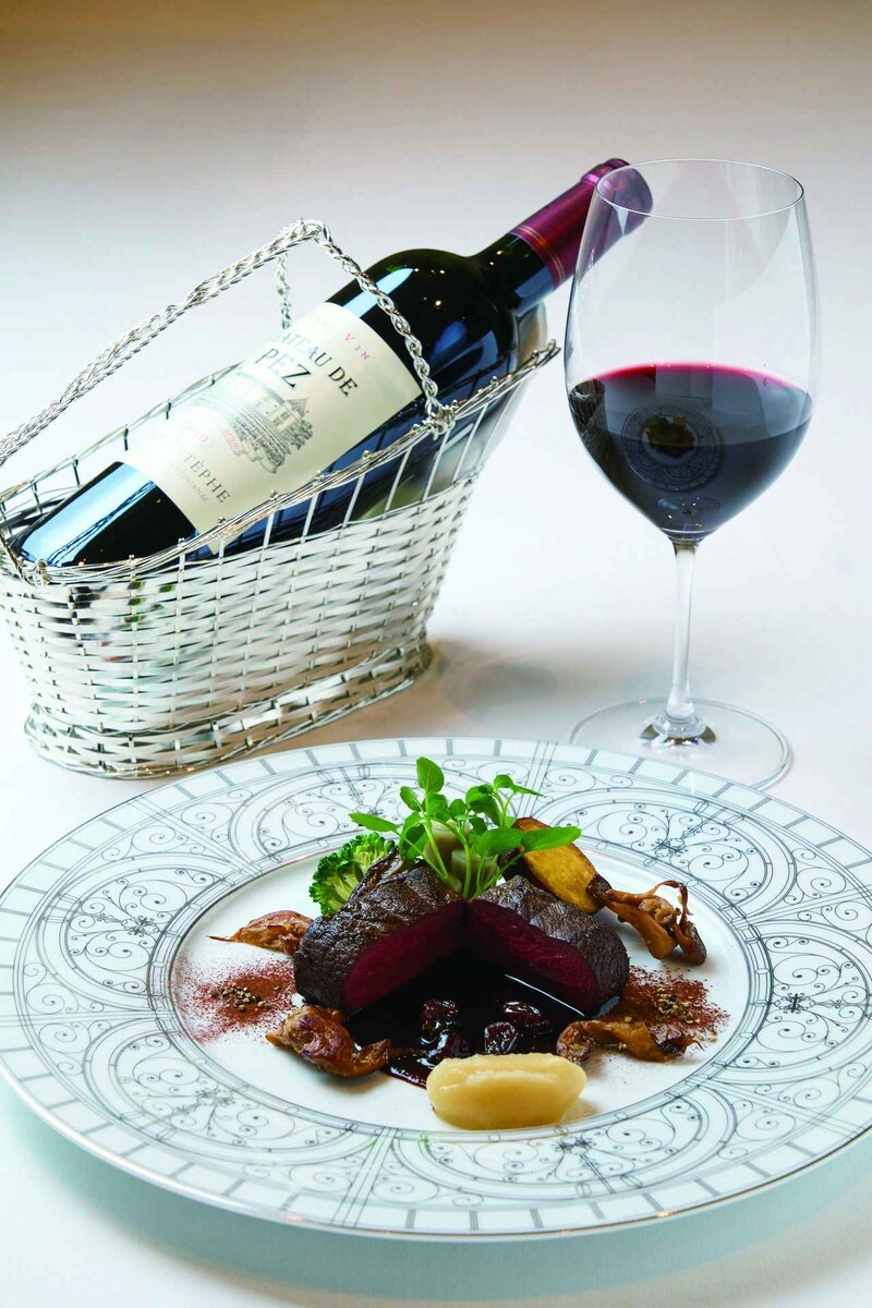 画像: メインの「蝦夷鹿背肉のロースト 野生のキノコ添え 八ヶ岳こけもものソース」と、ボルドー地方サンテステフ最古のシャトーの一つ『シャトー・ド・ペズ 2010年』。熟成を経た滑らかなテクスチャーと、鉄分を感じさせるほどの赤身肉の滋味深い味わいが口の中で溶け合う至福のマリアージュ