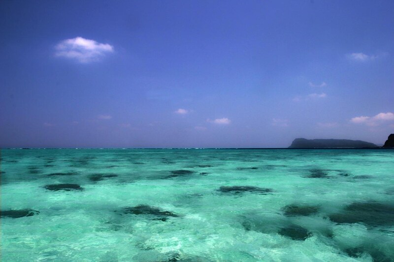 画像: 仕立船でウダラ浜に向かうのだが、網取湾に入ると船の周囲は素晴らしいコーラルブルーに包まれた。