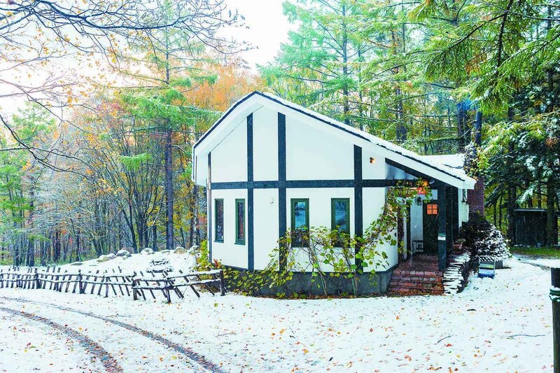 画像: 「新富良野プリンスホテル」敷地内の林をバックにかわいらしい佇まい。建物は移転開業にあたり新築したもので、倉本聰氏が店舗設計やロゴデザインに関わった。訪れたこの日、富良野にちょうど初雪が。食事を終えて店を出るころには、ふかふかの新雪が積もっていた