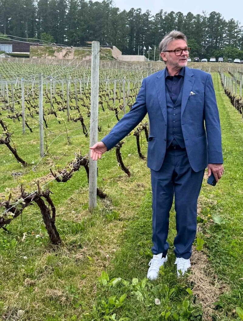 画像: 「NIKI Hills Winery」のメルロ畑を視察するトルシエ氏。旭台の土壌や収量制限など、仁木町ならではの栽培環境について説明を受けながら熱心に耳を傾けた