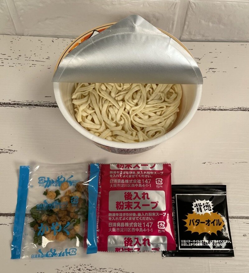日清食品「日清どん兵衛背徳味噌バタークリーミーうどん」　構成は「かやく」「後入れ粉末スープ」、そして注目の「背徳バターオイル」