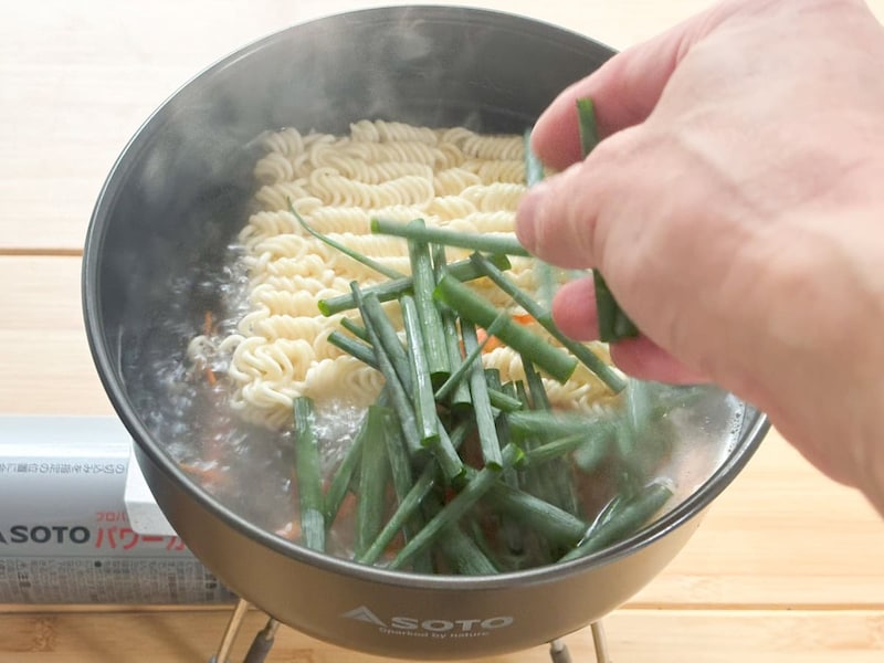 ニンジンの色が変わったら小ネギ、水洗いしたもやしを投入