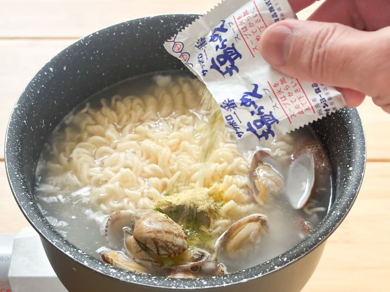らにアサリを加え、付属の調味料を振りかけてから麺をほぐす