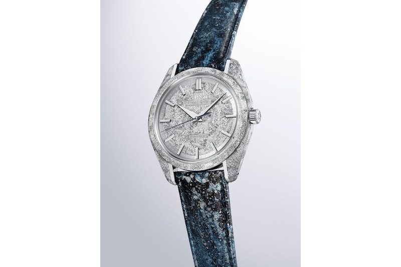 京都レザーによるストラップには、躍動感のある水の流れと岩にはじける水しぶきの輝きを、手加工の箔押しで表現