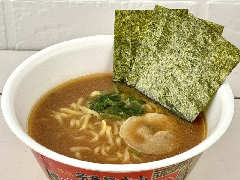 ローソン×明星食品
横浜家系総本山 吉村家 豚骨醤油ラーメン／スープは豚骨と鶏の旨みをベースに醤油だれを合わせ、さらに鶏油（チーユ）を効かせた家系らしいストロングなコクがありありの仕上がりです。粉末と液体のダブルスープ構成により、奥行きのある味わいを実現。具材はチャーシュー、ほうれん草、のり、ねぎと王道の組み合わせです