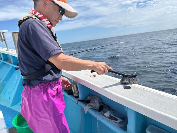 備え付けのブラシで船縁掃除、ウエアの汚れも防げる。 &copy;釣りビジョン