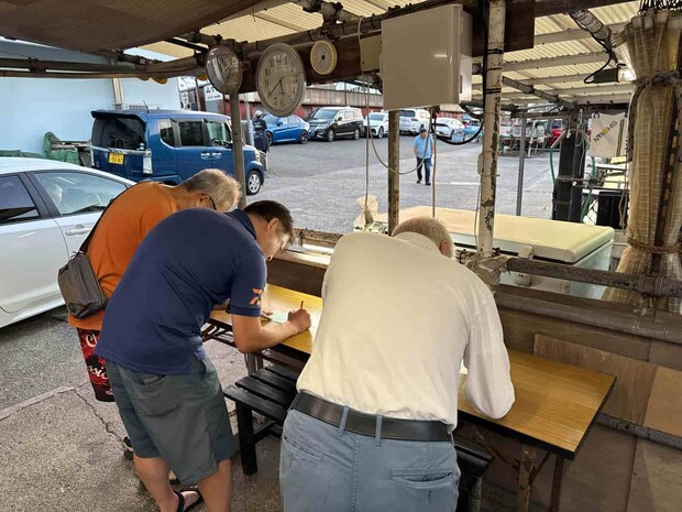 店先のテーブルで乗船カードを記入。 ©釣りビジョン