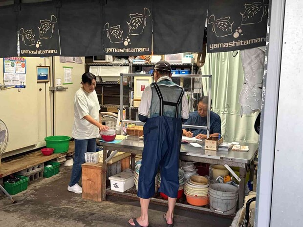 乗船カードを渡して乗船料を支払い、エサと番号札を受け取る。 ©釣りビジョン