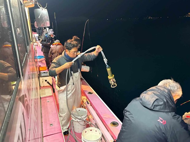 中乗りさんがアンカーを打って、集魚灯を投入する。 ©釣りビジョン
