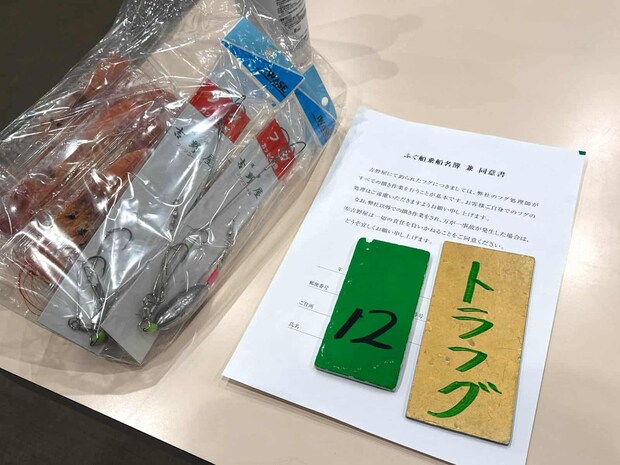 受付で渡される乗船名簿（同意書）と乗船券（金色）、番号札（緑色）。 &copy;釣りビジョン