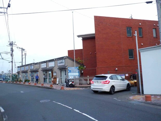 赤煉瓦の建物の手前を右折で駐車場、直進右の建物は船宿事務所棟。 &copy;釣りビジョン