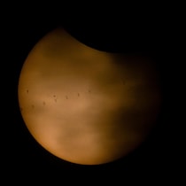 部分日食中の太陽の手前を通過するISS（国際宇宙ステーション）