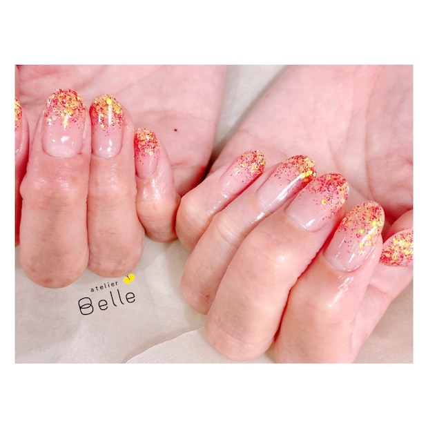 【グラデーションネイル】ゴールドとレッドが織りなすきらめくハニーレッドで印象的な指先に