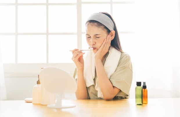 鏡を見るミドル世代の女性（歯磨き・困る）