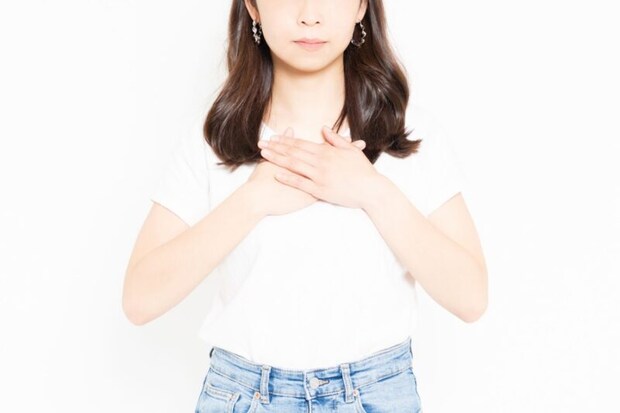 胸に手を当てる女性