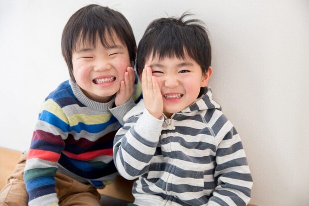 頬を抑える兄弟