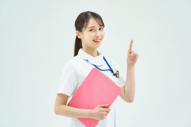 人差し指を立てる白衣の女性