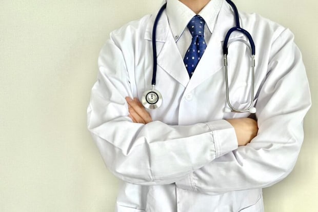 腕を組むポーズをする男性医師