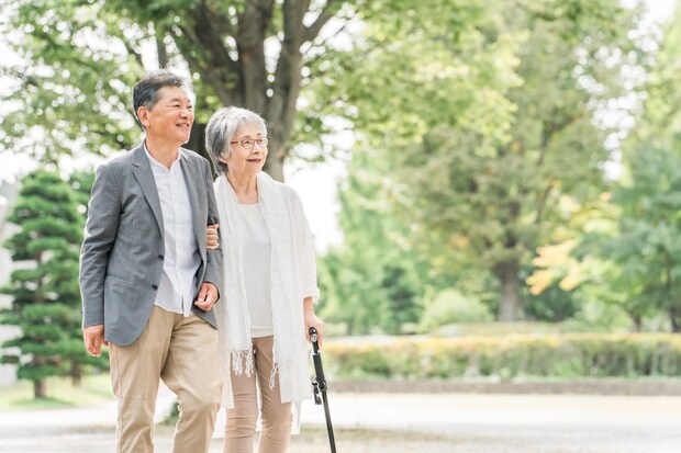 公園を話しながら歩く高齢者夫婦