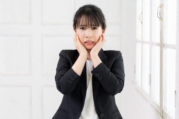 両手で顔を押さえる女性