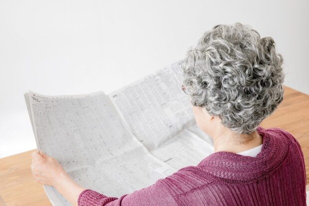 新聞を読む高齢者の女性