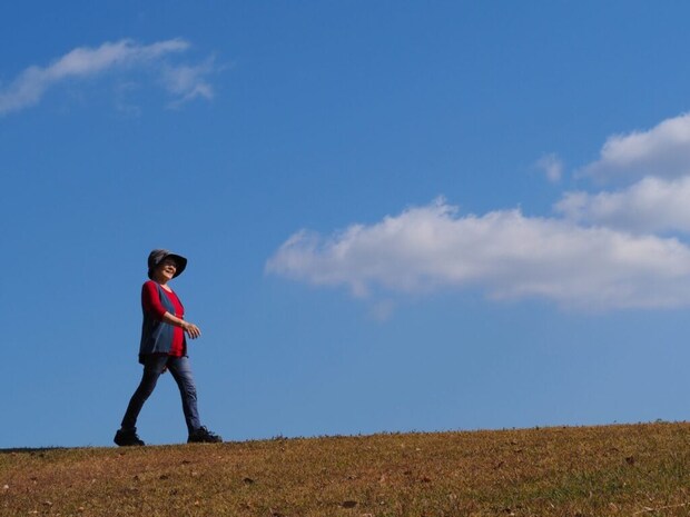 青空の下で歩く人
