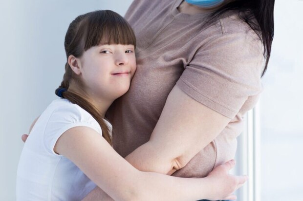 お母さんに抱き着くダウン症の子ども